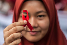 A student holds a red ribbon on Dec. 2, 2018, as part of an awareness event on World AIDS Day in Medan, North Sumatra. World AIDS Day has been observed today since 1988 to raise awareness of the AIDS pandemic.