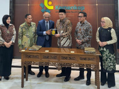Cooperatives Minister Ferry Juliantono (center right) presents a plaque to Mercantile & Maritime Energy Pte. Ltd. (MM Group) founder and CEO Murtaza Lakhani (center left) on Nov. 25 2025, during a signing ceremony for a used cooking oil project at the ministry’s offices in Setiabudi, South Jakarta.