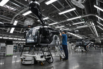 Employees work on the assembly line for the electric flying car Land Aircraft Carrier at a factory of Xpeng's subsidiary Aridge in Guangzhou, in southern China's Guangdong province on Nov. 6, 2025.