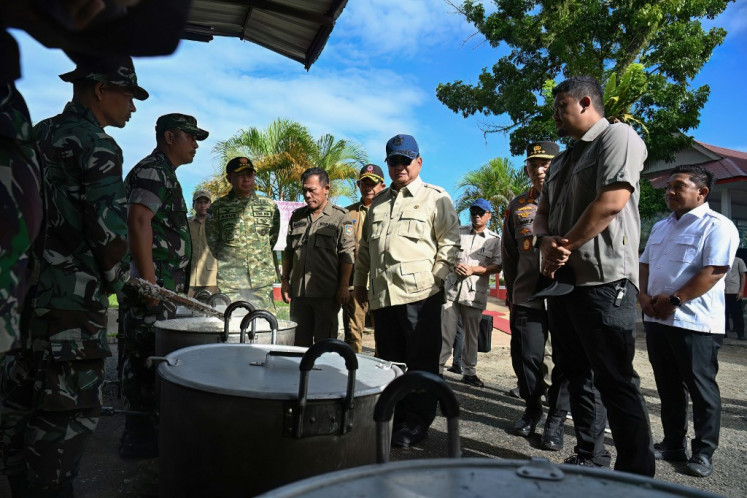 President Prabowo Subianto (center) inspects the operation of a public kitchen preparing food for flash flood survivors at an evacuation post in Pandan, Central Tapanuli, North Sumatra province, on December 1, 2025. 