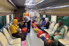 Train operators check passengers’ entry cards in a special carriage for farmers and small traders on Dec. 1. PT Kereta Api Indonesia (KAI) has introduced the carriage on all commuter trains between Rangkasbitung and Merak in Banten to strengthen rural supply chains and support local economies.
