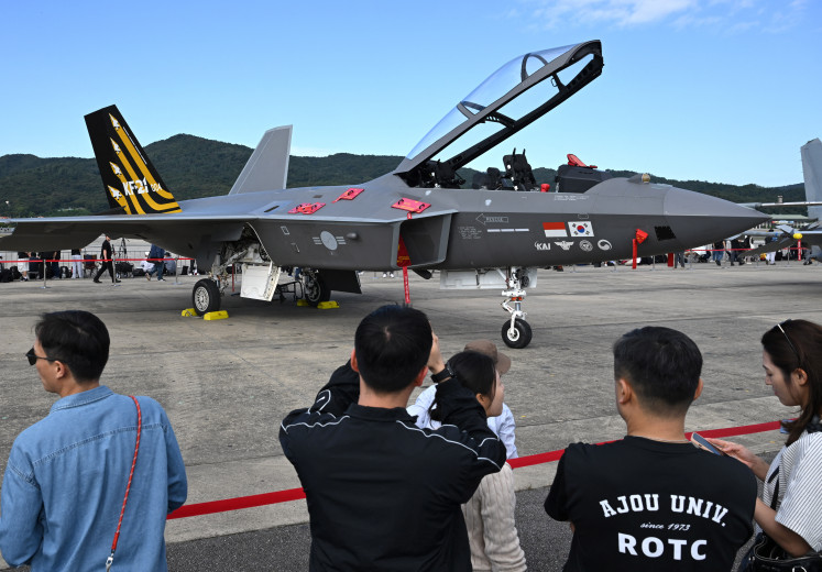 Visitors look at a KF-21 Boramae jet fighter during the Seoul International Aerospace and Defense Exhibition (ADEX) at a military airport in Seongnam, South Korea, on Oct. 17, 2025. The jet fighter was jointly developed with Indonesia as a minority partner. 