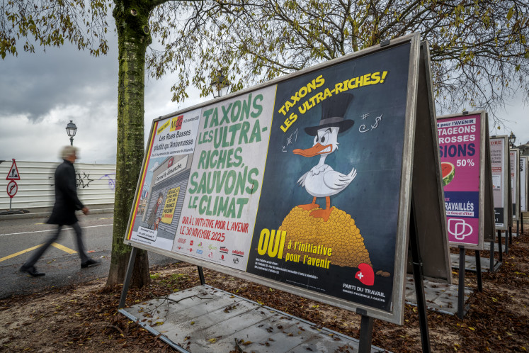 Posters promoting an initiative to tax the superrich to help finance Switzerland&rsquo;s global warming policies line a street in Geneva on Nov. 25, 2025, ahead of a referendum on Nov. 30.