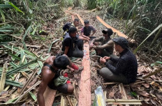 Police detectives arrest three illegal loggers who were resting after processing wooden logs into planks inside a forest in Pulau Muda village, Teluk Meranti district, Pelalawan regency, Riau, on Nov. 28, 2025. The police have arrested a total of six illegal loggers and confiscated three chainsaws from the suspects.
