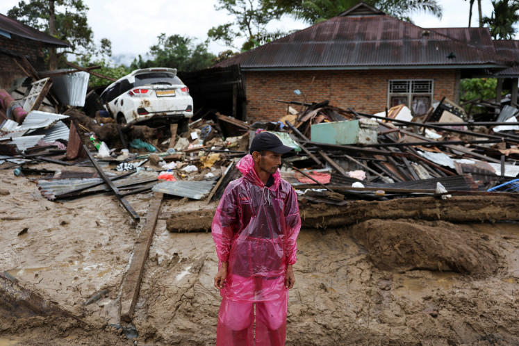 Imuwarizal, 52, stands while looking for his sister who has been missing following a deadly flash flood in Palembayan, Agam regency, West Sumatra, December 2, 2025. 