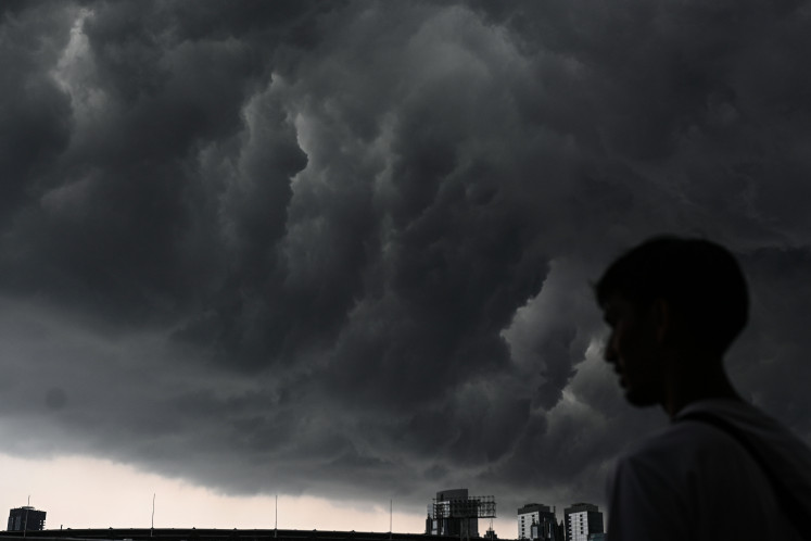 A resident observes thick clouds on Nov. 15 covering the Senayan area in Jakarta. The Meteorology, Climatology and Geophysics Agency (BMKG) asked the public to remain alert for potential extreme weather expected through Nov. 20, due to a combination of atmospheric phenomena that triggered significant rain cloud formation across Indonesia.