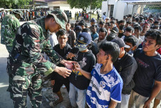 Villagers receive free sacks of rice from the Indonesian Military, distributed amid relief efforts from the government's rice warehouse at Sarudik, in Central Tapanuli, North Sumatra province, on December 3, 2025. 