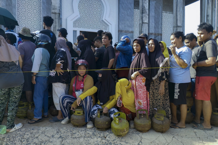 Villagers queue to purchase cooking gas cylinders on Dec. 3 at Pandan, Central Tapanuli, North Sumatra,in the aftermath of flash floods that struck their area. There is growing frustration among survivors of catastrophic flooding and landslides over the pace of the rescue effort and aid delivery.