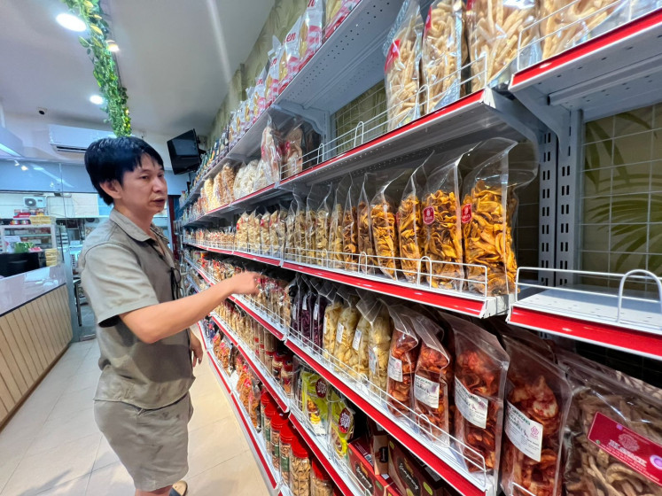 Store owner Edward display snacks on Dec. 4, 2025, at his store at Windsor Phase shopping avenue in Batam city, Riau Islands. Micro, small and medium enterprises in Batam are finding it difficult to transport their products to other regions due to having to pay high taxes to enter Indonesian customs through the Batam free trade zone.