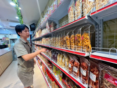 Store owner Edward display snacks on Dec. 4, 2025, at his store at Windsor Phase shopping avenue in Batam city, Riau Islands. Micro, small and medium enterprises in Batam are finding it difficult to transport their products to other regions due to having to pay high taxes to enter Indonesian customs through the Batam free trade zone.