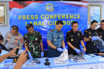Cirebon Naval Base commander Lt. Col. Faisal Yanova Tanjung (center) presents sports apparel seized from a smuggling attempt on Dec. 2, 2025, during a press conference alongside regional officials at the naval base in Cirebon, West Java. The Indonesian Navy foiled an attempt to smuggle 41,280 items of sports clothing worth an estimated Rp 6.1 billion (US$366,124) from Pontianak.
