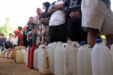 Residents line up to buy fuel on Thursday at a gas station in Pinangsori District, Central Tapanuli Regency, North Sumatra. A landslide and flash flood limited fuel supplies after road access was cut off on Nov. 25. 