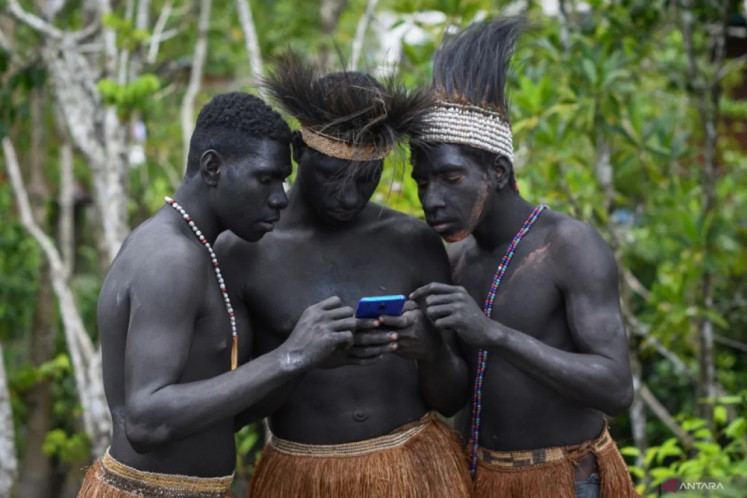 Remote connection: Asmat tribespeople try a smartphone on June 1, 2023, in the rural district of Agats in Asmat regency, South Papua.