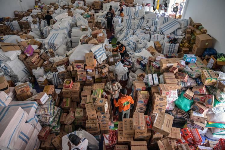 Volunteers ready packages of relief aid for flood-affected areas on [DATE], at the Sidoarjo Disaster Mitigation Agency in East Java.