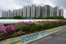 The logo of Forest City, a Malaysian development project in Johor state’s Gelang Patah launched under China's Belt and Road Initiative, marks a curb along an access road leading to a crop of towering condominiums on Sept. 1, 2023.