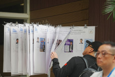 A voter checks on the candidates at a polling station in Tai Po during the Legislative Council general election in Hong Kong on December 7, 2025.