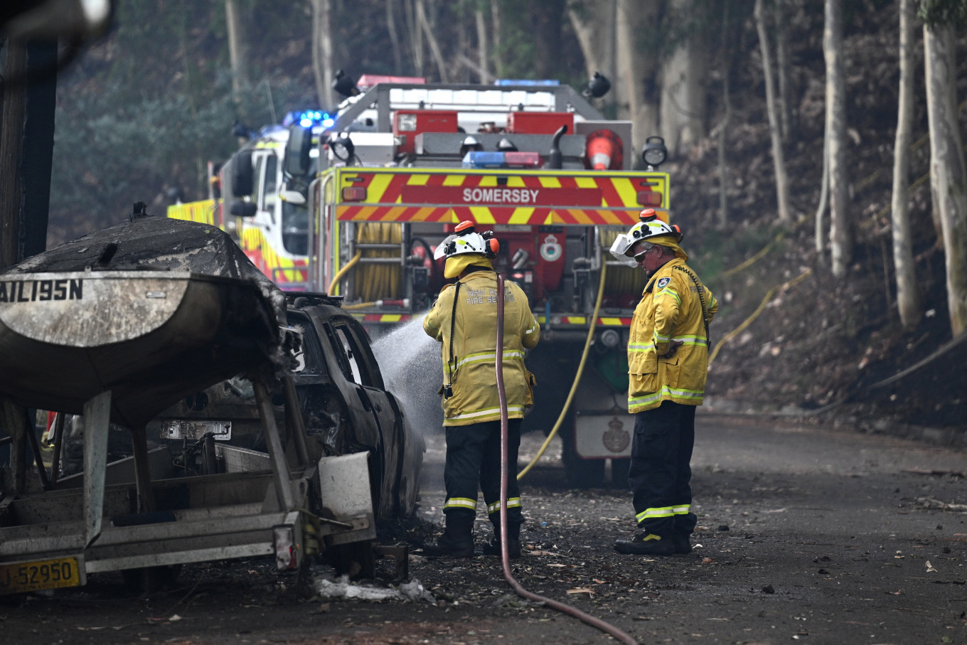 Firefighters work at the site where bushfire destroyed homes along Glenrock Parade, in Koolewong on the Central Coast of New South Wales, Australia on December 6, 2025.