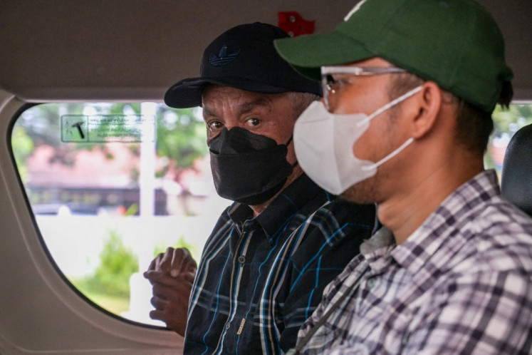 Dutch prisoner Ali Tokman (center) sits in a car as he leaves the Surabaya Prison in Porong, East Java province on December 7, 2025, before being transferred to Jakarta for deportation under an agreement between Indonesia and the Netherlands. 