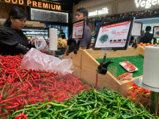 A customer picks red chilies at a supermarket in Batam, Riau Islands, on Dec. 7, 2025. Natural disasters in northern Sumatra have caused the red chili price to surge to Rp 120,000 (US$7.19) per kilogram while green chili is sold at Rp 100,000 per kg.