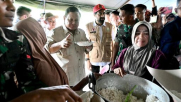 President Prabowo Subianto tastes the lunch menu prepared for evacuees, rice and skipjack tuna, on Dec. 7 at a disaster relief tent in Bireuen regency, Aceh province.