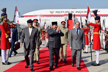 This handout photograph taken and released by the Pakistan's President Office on Monday shows Indonesia's President Prabowo Subianto (center) walking along with his Pakistani counterpart Asif Ali Zardari (left) and Prime Minister Shehbaz Sharif upon his arrival at the Nur Khan military airbase in Rawalpindi.