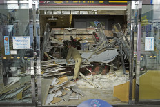 A worker cleans up a commercial facility on Tuesday in Hachinohe, Aomori prefecture, northeastern Japan, following a strong earthquake the previous night.