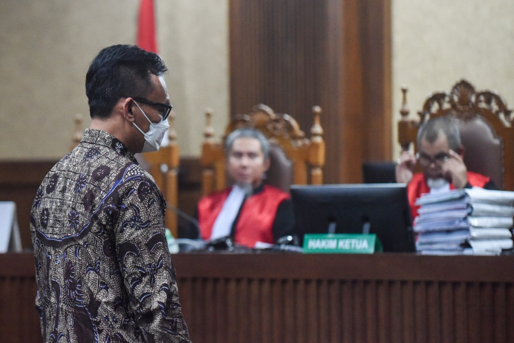 Former Central Jakarta District Court deputy head and graft defendant Muhammad Arif Nuryanta attends the verdict hearing against him on Dec. 3 at the Jakarta Corruption Court in Jakarta. The judges sentenced Arif to a 12.5-year imprisonment and a Rp 500 million fine for accepting bribes to influence the verdict against three companies in a corruption case pertaining to crude palm oil exports.