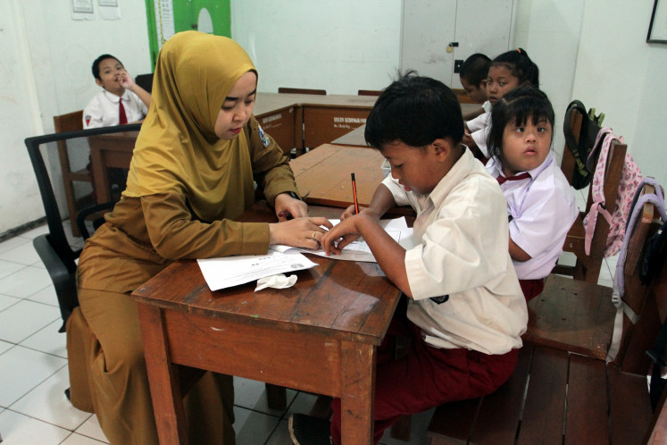 Semester showdown: Elementary school students work on math exams on Dec. 9, 2025, during an end-of-semester assessment at Kedungkandang SLB C special-needs school for autism in Malang, East Java. A total of 155 students from the elementary, junior high and senior high levels took part in the exams, which also included self-development subjects.