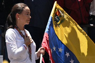 Venezuelan opposition leader Maria Corina Machado holds a Venezuelan national flag as she gestures from atop a truck during a demonstration to protest over the presidential election results, in Caracas on August 3, 2024. Venezuela opposition leader will not stay in 'exile' after receiving Nobel Peace Prize in Oslo, a representative said on December 9, 2025.