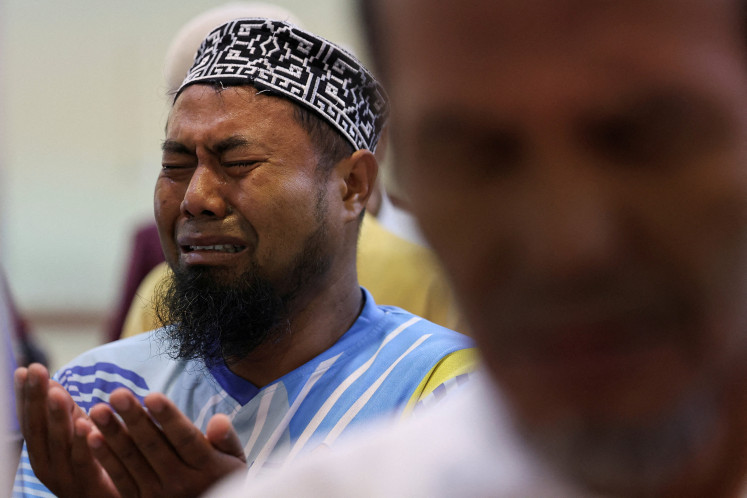 Afridoni, a local man, cries while attending funeral prayers for unidentified victims of the recent flash floods and landslides at the Great mosque of Syekh Ahmad Khatib Al-Minangkabawi in Padang, West Sumatra, December 10, 2025. 