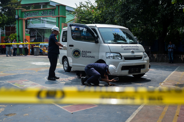 Jakarta Transportation Agency officers inspect a free-meals delivery vehicle that struck students and a teacher at SDN Kalibaru 01 Pagi state elementary school in Cilincing, North Jakarta, on Dec. 11, 2025. The incident left 20 students and a teacher injured and requiring treatment at nearby hospitals.