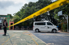 Police officers stand guard on Dec. 11, 2025, near the free-meals delivery vehicle that struck students and a teacher at SDN Kalibaru 01 Pagi state elementary school in Cilincing, North Jakarta. The incident left 20 students and one teacher injured and requiring treatment at nearby hospitals.