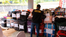 An officer with the Batam Customs and Excise Office inspects luggage containing used clothing on Dec. 10, 2025, in Batam, Riau Islands. As of Dec. 8, the Batam Customs had confiscated 682 packages of used clothing. 