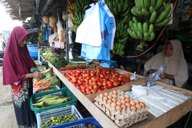 Disrupted market: A woman selects vegetables sold by vendors on Dec. 9, 2025, at the Pangwa traditional market in Pidie Jaya, Aceh. The government has reported rising prices of key staple foods across various regions as widespread flooding in northern Sumatra and torrential rains continue to disrupt harvests and supply chains.