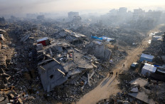 Palestinians walk past the rubble of destroyed buildings in Gaza City on Nov. 19, 2025 amid a ceasefire between Israel and Hamas.
