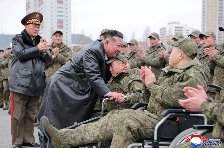 North Korean leader Kim Jong Un (third left) embraces a soldier during a welcoming ceremony at the April 25 Cultural and Tourism Center in Pyongyang, North Korea, on Dec. 12, 2025 for members of the 528th Engineer Regiment after they returned from an overseas mission.