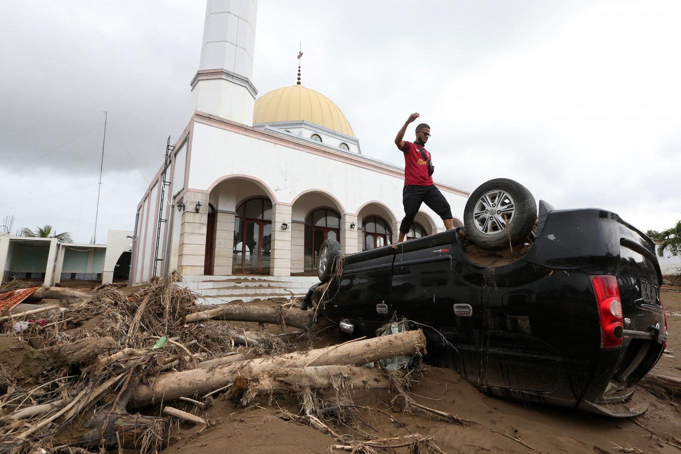 People stand atop vehicles damaged by flooding from the overflowing Meureudu River on Dec. 13 at the yard of Dayah Tgk Chik Pante Geulima Mosque in Pidie Jaya, Aceh, Indonesia. According to preliminary data from the emergency response services, flooding since the river overflowed on Nov. 26 damaged or inundated 122 places of worship and 10,530 homes, forcing 5,729 families, or 20,114 people, to evacuate. 