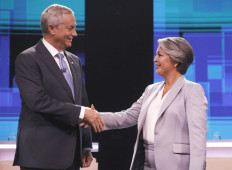 Chile's presidential candidates Jose Antonio Kast of the Partido Republicano party and Jeannette Jara, of the Unidad por Chile coalition, pose for pictures before a debate organized by the National Television Association in Santiago, on December 9, 2025. 