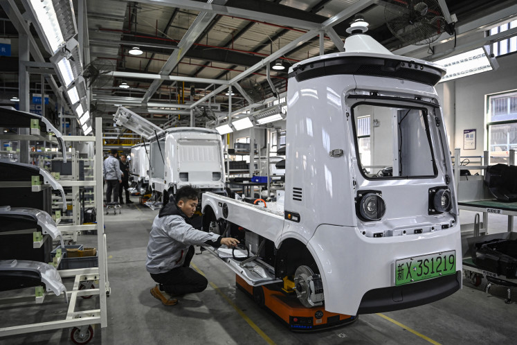 Employees work on a Neolix X3 vehicle production line at a factory of Chinese autonomous delivery vehicle maker Neolix in Yancheng, in eastern China's Jiangsu province, on Dec. 4, 2025.