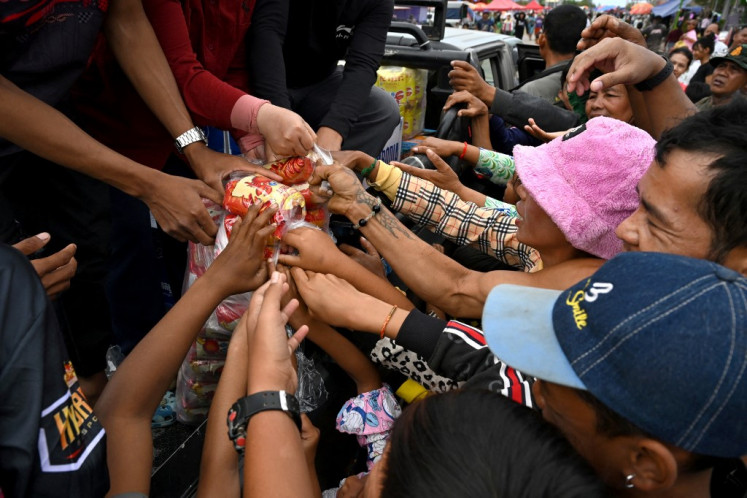 Displaced residents gather to receive aid at a temporary camp in Cambodia's Banteay Meanchey province on December 14, 2025, amid clashes along Cambodia-Thailand border. 