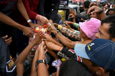 Displaced residents gather to receive aid at a temporary camp in Cambodia's Banteay Meanchey province on December 14, 2025, amid clashes along Cambodia-Thailand border. 