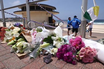 Flowers are placed outside the lifeguard tower at the Bondi Pavillion in memory of the victims of a shooting at Bondi Beach, in Sydney on December 15, 2025. A father-and-son team toting long-barreled guns shot and killed 15 people including a 10-year-old girl at Sydney's Bondi Beach on December 14, with authorities labelling it an antisemitic terrorist attack on a Jewish festival.