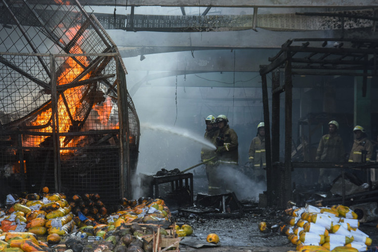 Firefighters extinguish a blaze at Kramat Jati wholesale market, East Jakarta, on Dec. 15, 2025. At least 350 stalls were burned.
