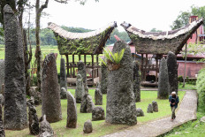 A visitor walks past &lsquo;batu simbuang&rsquo; (menhir) on Dec. 15, 2025, among the 102 menhirs that stand at Kalimbuang Bori&rsquo;, a megalithic tourist site in Sesean district, North Toraja regency, South Sulawesi.