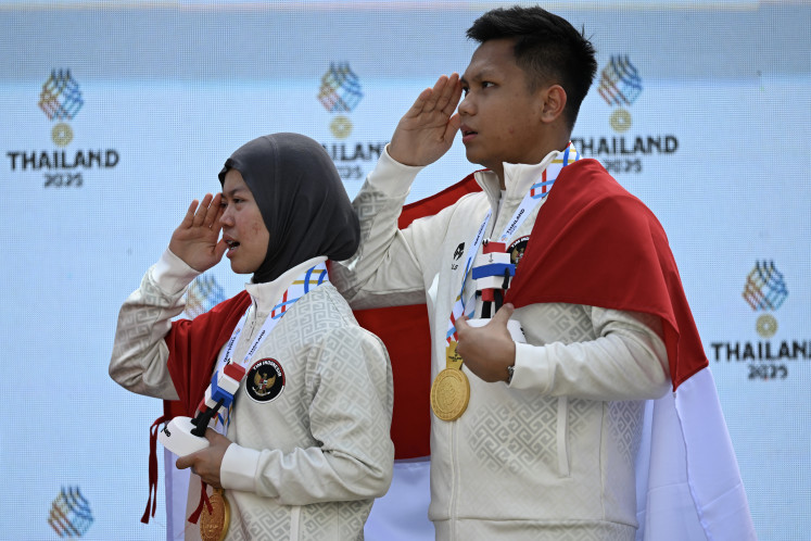 Bullseye glory:Indonesian shooters Muhammad Iqbal Raia Prabowo (right) and Arista Perdana Putri Darmoyo salute the national flag during a medal giving ceremony on Monday, Dec. 15, 2025, after winning the gold medal during the mixed team 10-meter air rifle final at the 2025 SEA Games at the Photharam Shooting Range in Bangkok. They defeated Vietnam&rsquo;s mixed team of Thu Vinh Trinh and Quang Huy Pham by a score of 17-9.