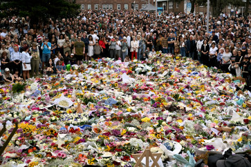 Sea of flowers: Mourners stand on Tuesday, near tributes piled together in memory of the victims of a shooting at Bondi Beach, in Sydney, Australia. Australia&rsquo;s leaders have agreed to toughen gun laws after attackers killed 15 people at a Jewish festival on Bondi Beach, the worst mass shooting in decades decried as anti-Semitic &ldquo;terrorism&rdquo; by authorities.