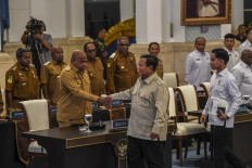President Prabowo Subianto (center), accompanied by Vice President Gibran Rakabuming Raka (right), shakes hands with Papua Governor Mathius Fakhiri (left) on Dec. 16, 2025, prior to a meeting with 46 regional leaders from Papua along with 10 executive committee members of the Acceleration of Papua&rsquo;s Special Autonomy Development at the State Palace in Central Jakarta.