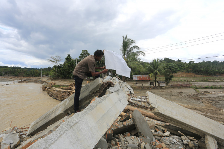 Flooded and forgotten: A person puts a white flag in front of his damaged house on Dec. 17, 2025, following severe flooding in Jambak village, Pante Ceureumen district, West Aceh, Aceh. The white flags were raised by residents of the village to call on the government to immediately declare the devastation in Sumatra a national disaster, which will allow for international assistance to enter and help accelerate recovery efforts.