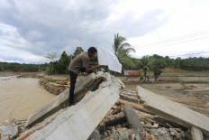 Flooded and forgotten: A person puts a white flag in front of his damaged house on Dec. 17, 2025, following severe flooding in Jambak village, Pante Ceureumen district, West Aceh, Aceh. The white flags were raised by residents of the village to call on the government to immediately declare the devastation in Sumatra a national disaster, which will allow for international assistance to enter and help accelerate recovery efforts.