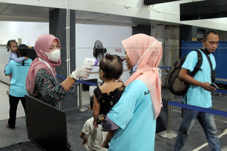 Home sweet home: Health workers check the body temperature of a migrant worker and her child upon arrival on Dec. 14, 2025 at Dumai Port in Riau, following their deportation from Melaka, Malaysia.